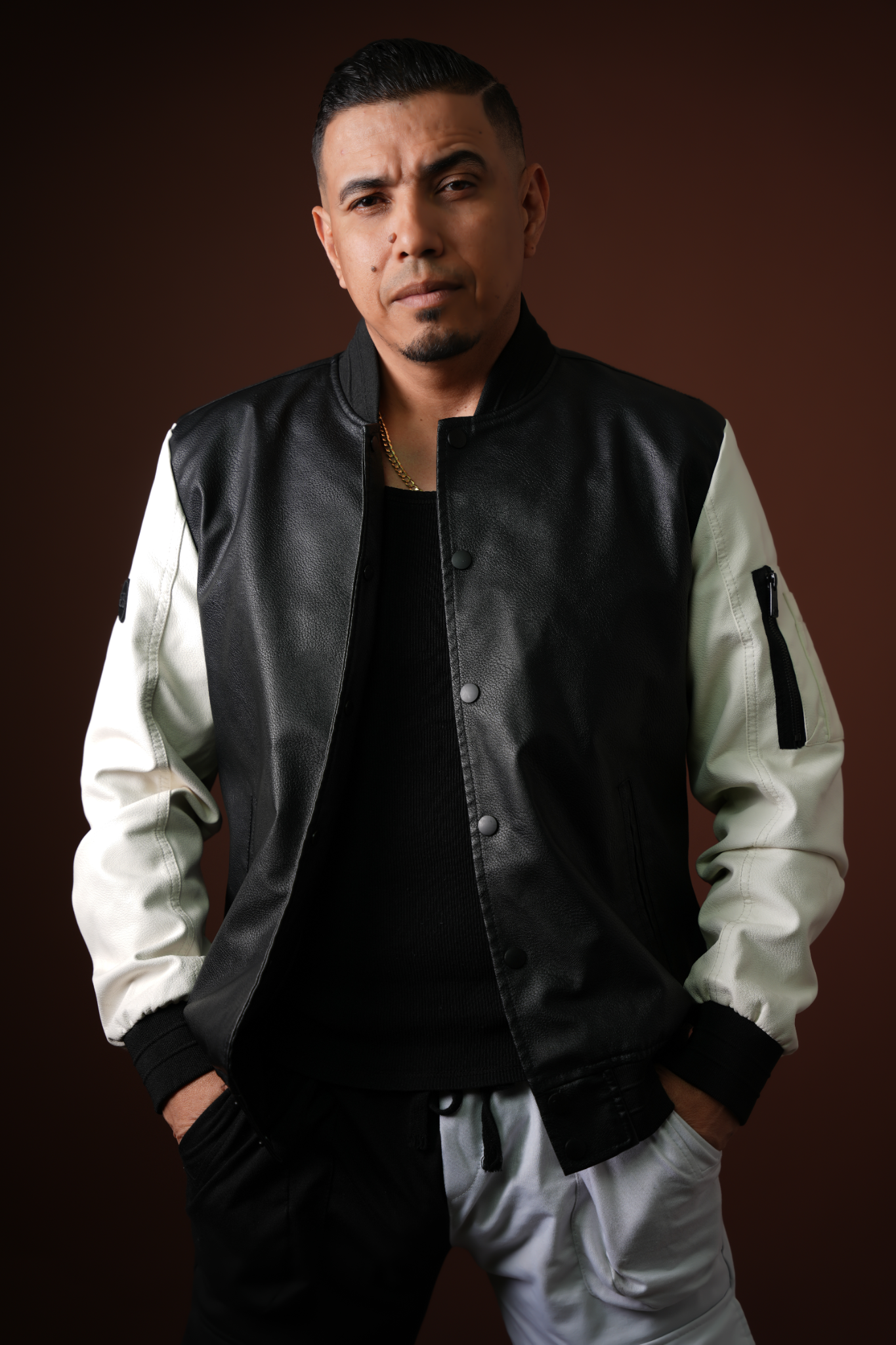 Retrato frontal de El Guardador con chaqueta negra y blanca
