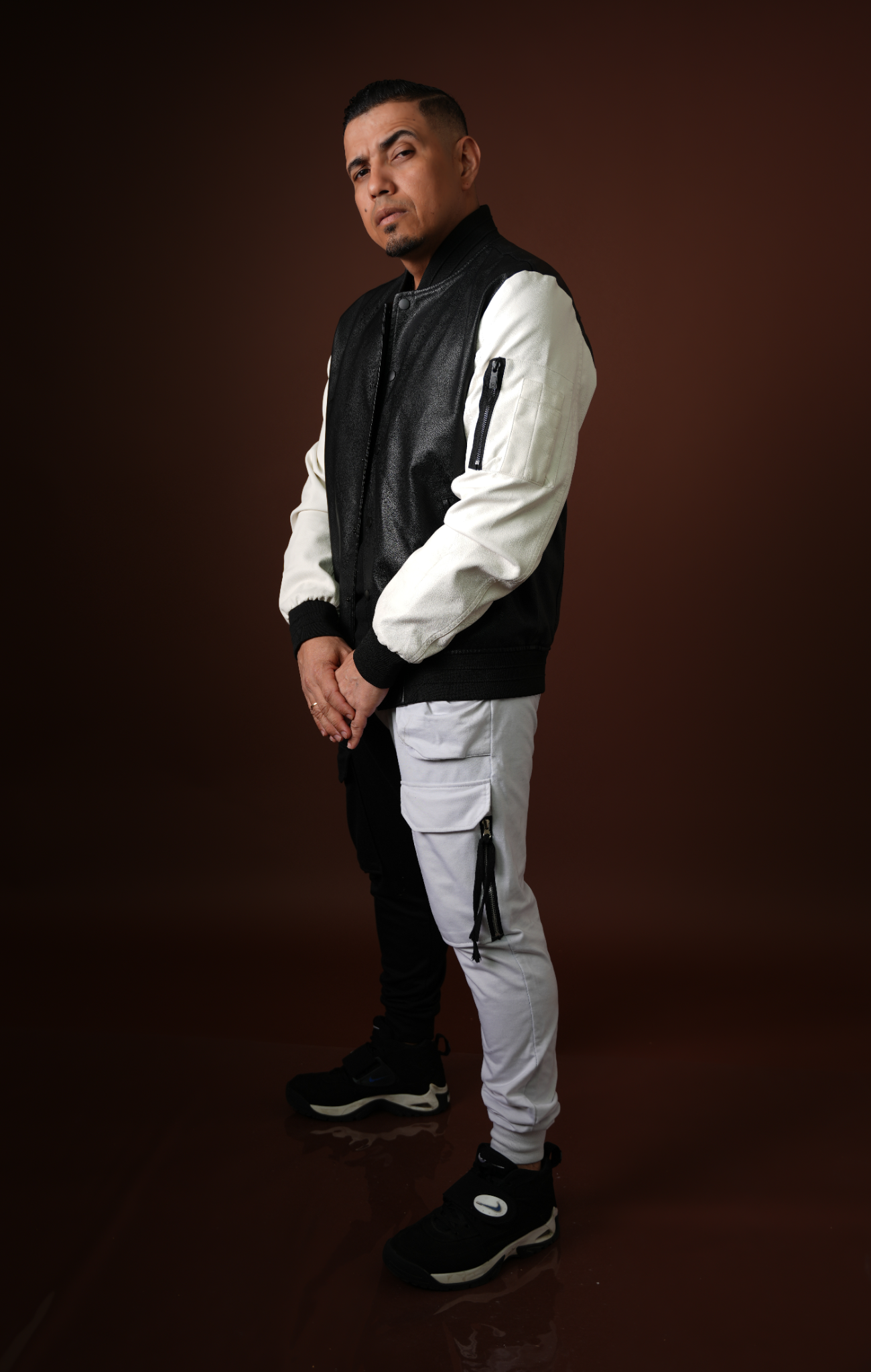 El Guardador posando de pie en estudio con vestuario bicolor