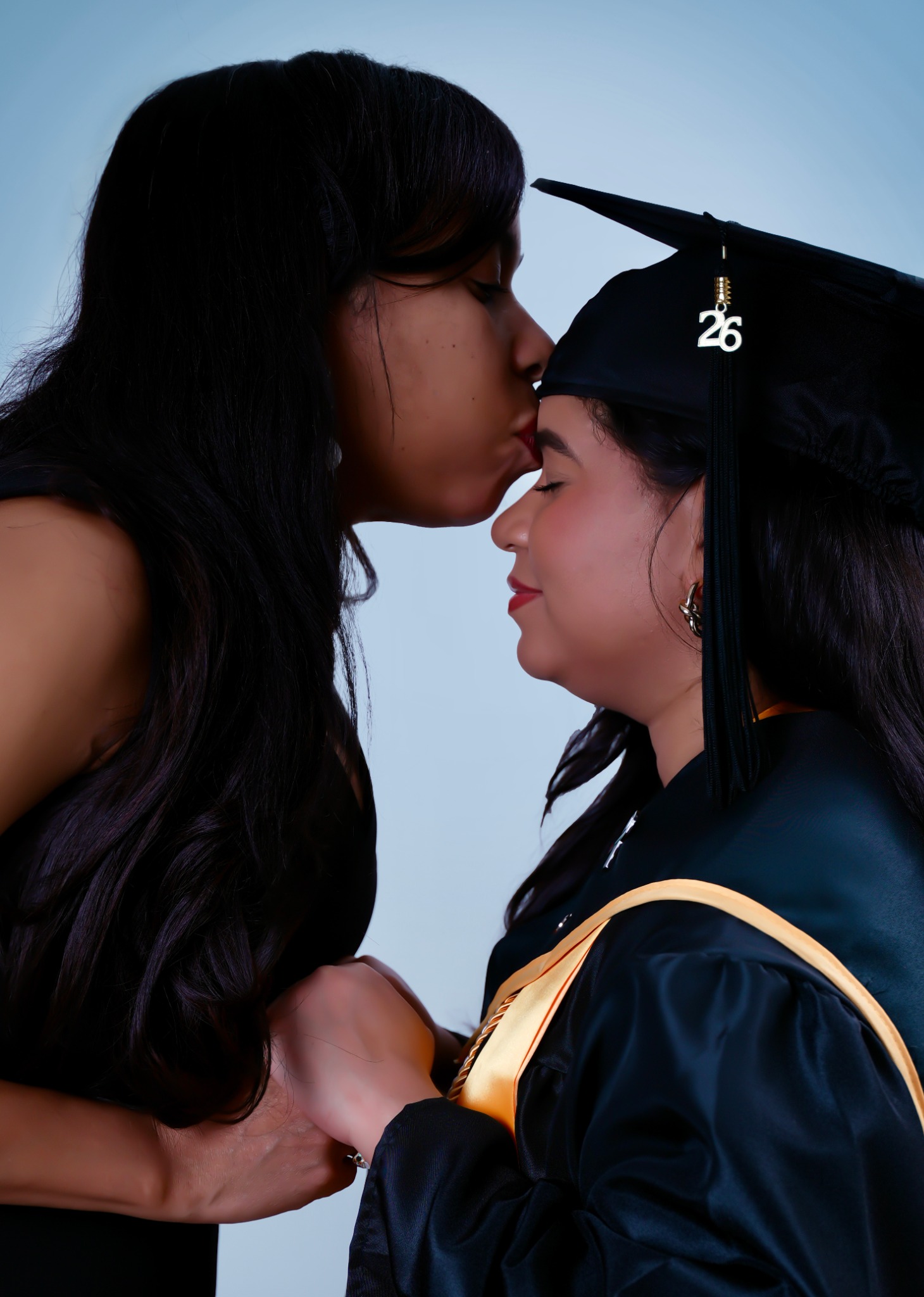 Primer plano emotivo entre mamá y graduada
