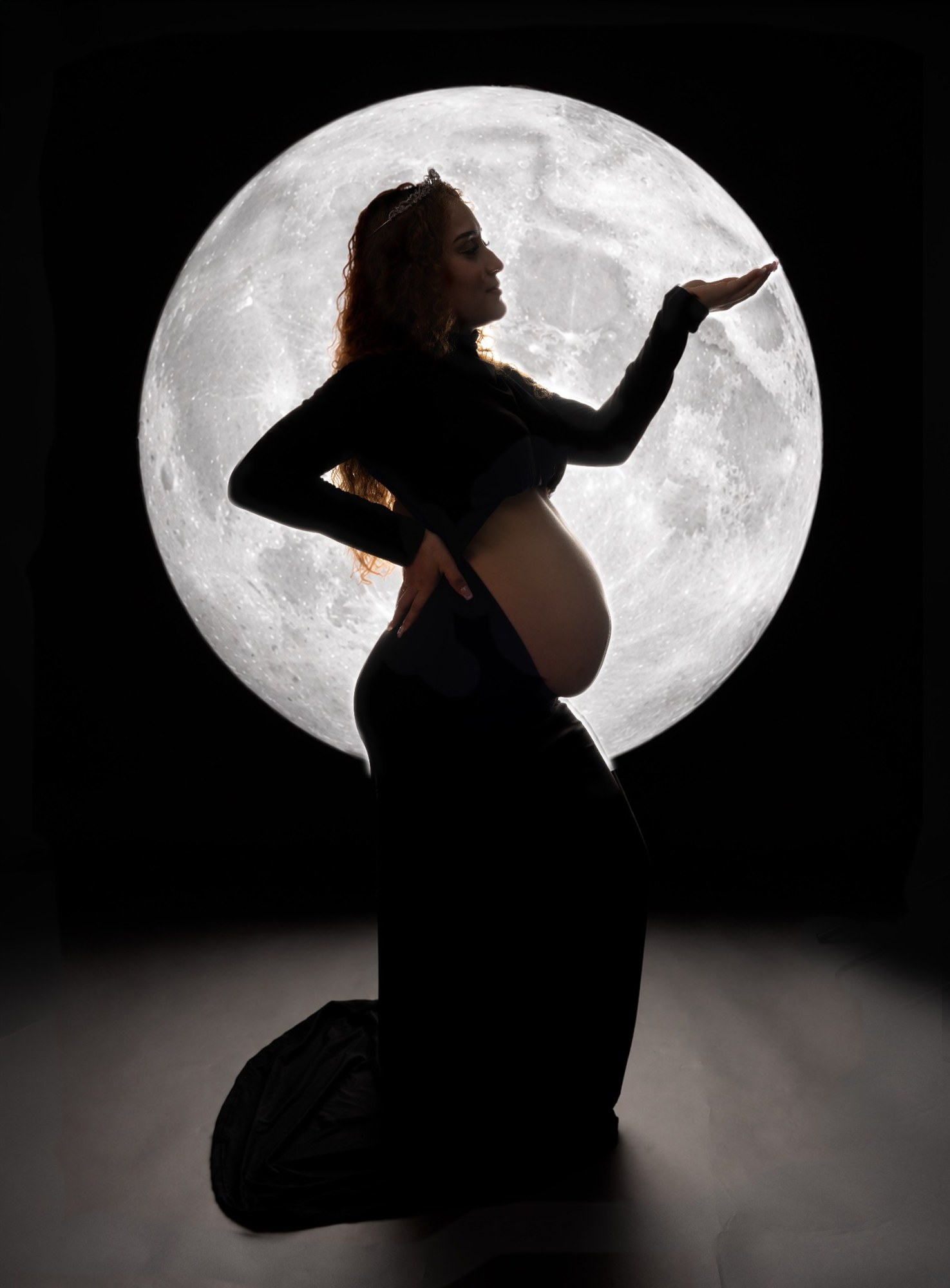 Retrato de maternidad frente a una luna iluminada