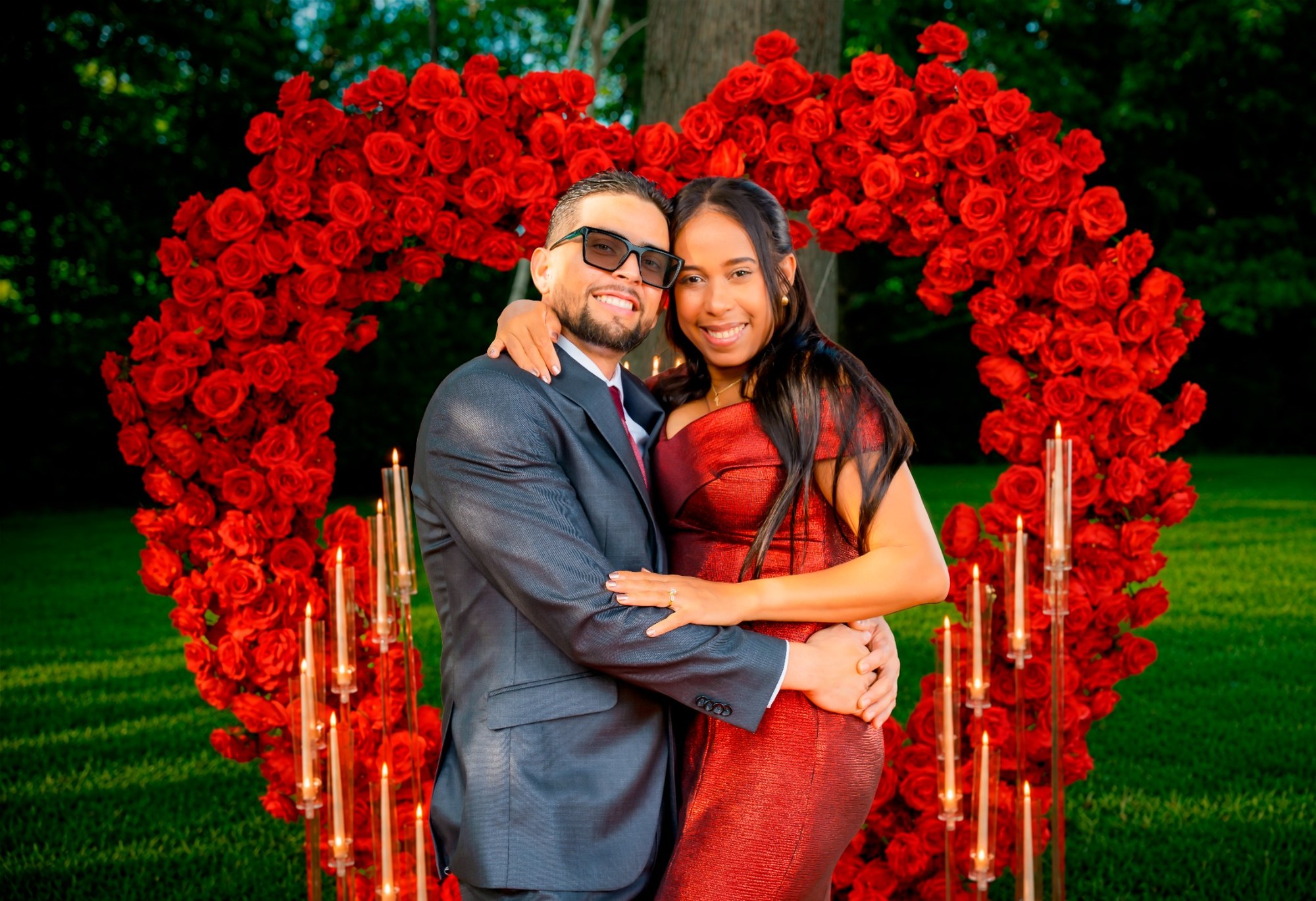 Pareja frente a un arco de rosas rojas