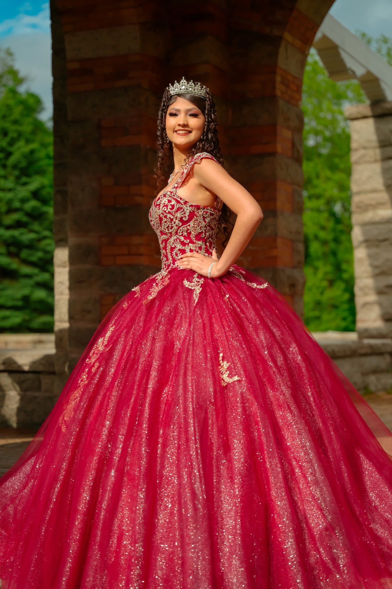 Quinceañera de pie con vestido rojo